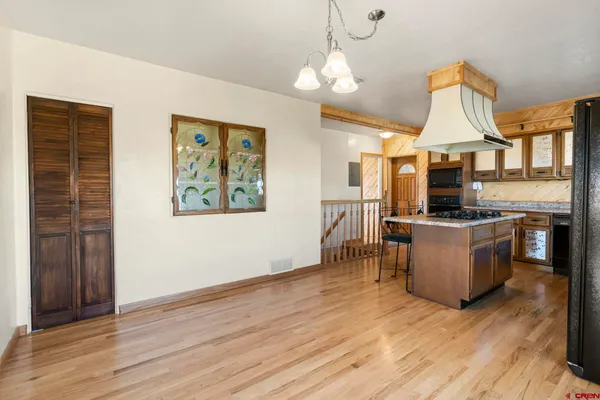 a kitchen with a stove a refrigerator and wooden floor
