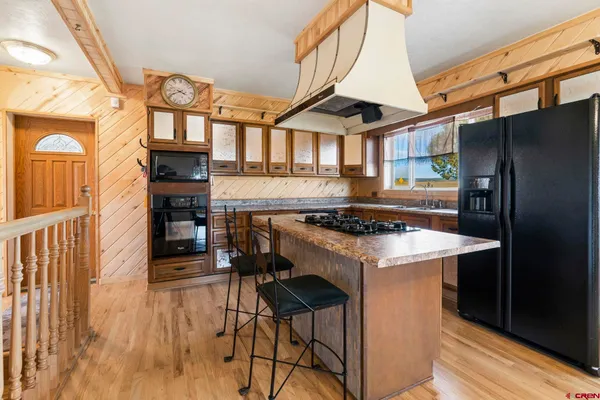 a view of a kitchen with furniture and wooden floor