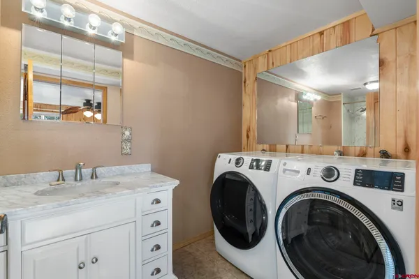a bathroom with a granite countertop tub sink toilet and mirror