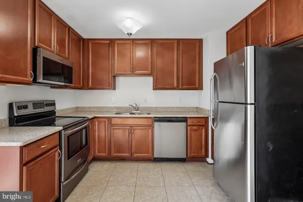 a kitchen with stainless steel appliances granite countertop a refrigerator stove a sink and a microwave