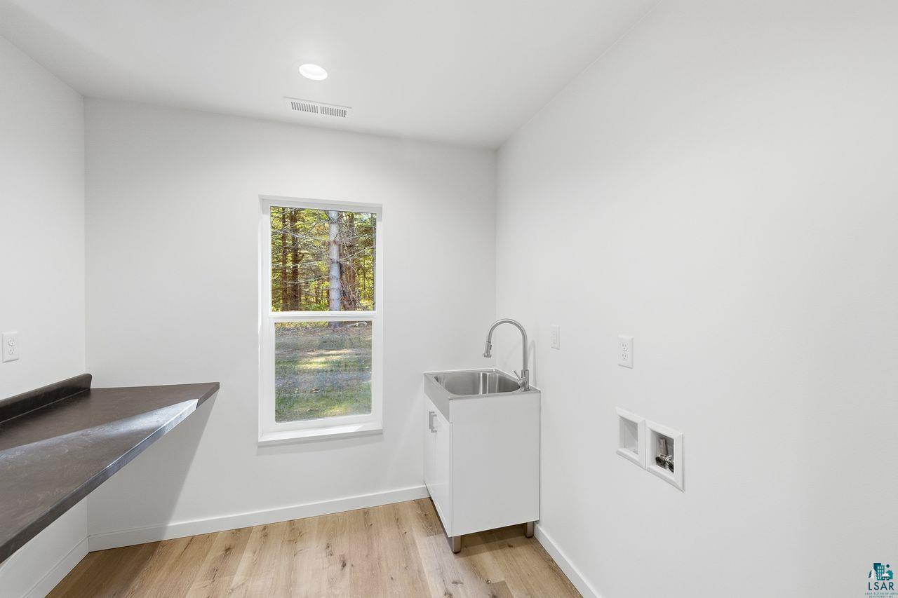 65352 Adler Road Marengo, WI 54855 - Photo 9 of 24 Utility sink with cabinet, wood-finish flooring, recessed lighting, and wall-mounted counter space