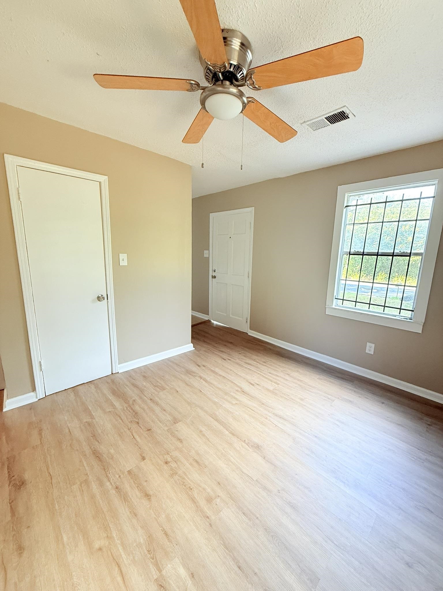 931 Calvin Road Memphis, TN 38109 - Photo 5 of 15 Unfurnished bedroom featuring a textured ceiling, light wood-type flooring, and a ceiling fan