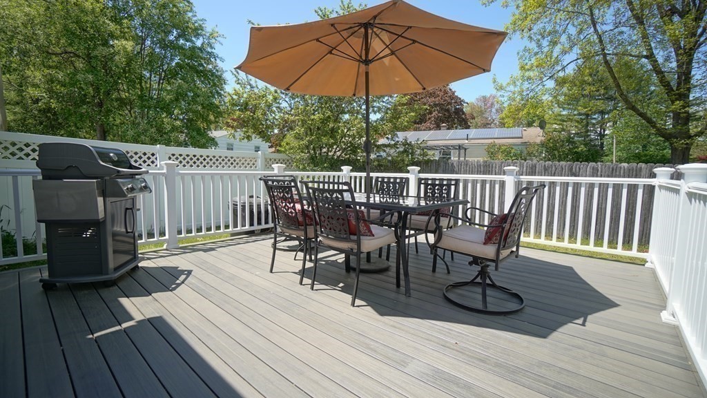245 Fair Oak Road Springfield, MA 01128 - Photo 3 of 37 a view of deck with table and chairs under an umbrella with wooden floor