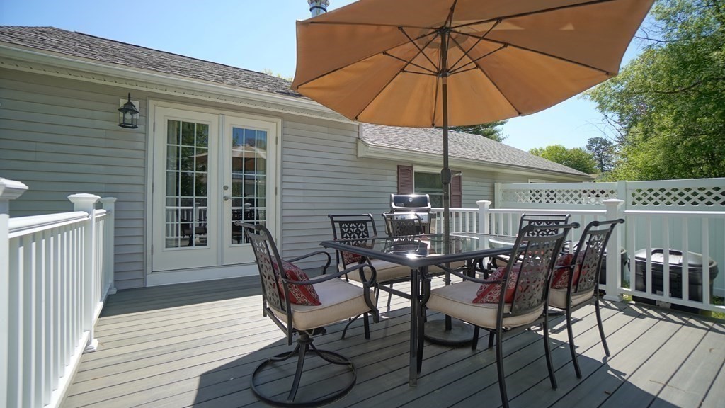 245 Fair Oak Road Springfield, MA 01128 - Photo 4 of 37 a view of a roof deck with table and chairs under an umbrella with wooden floor and fence