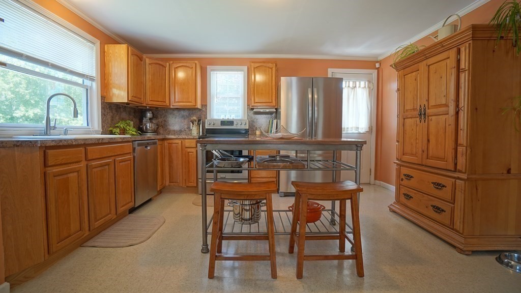 245 Fair Oak Road Springfield, MA 01128 - Photo 10 of 37 a kitchen with stainless steel appliances granite countertop wooden cabinets a dining table and chairs