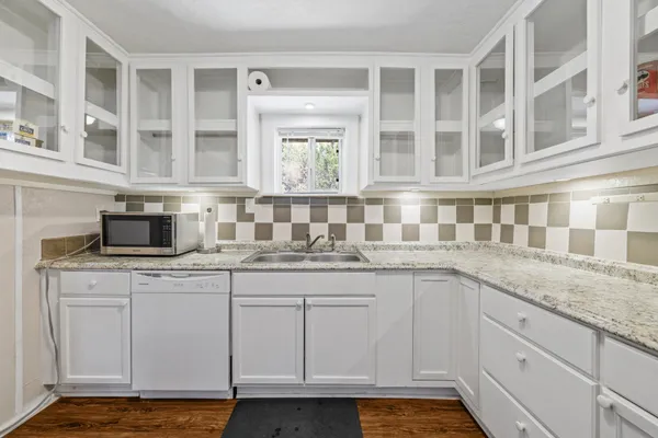 a kitchen with granite countertop a sink and cabinets
