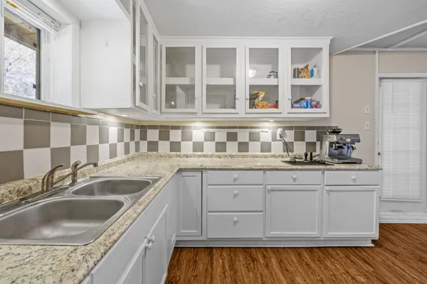 a kitchen with granite countertop a sink and cabinets