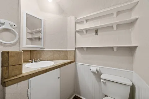 a bathroom with a sink a toilet and a mirror
