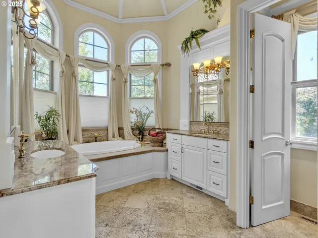 a large spacious bathroom with a granite countertop tub a mirror and a shower