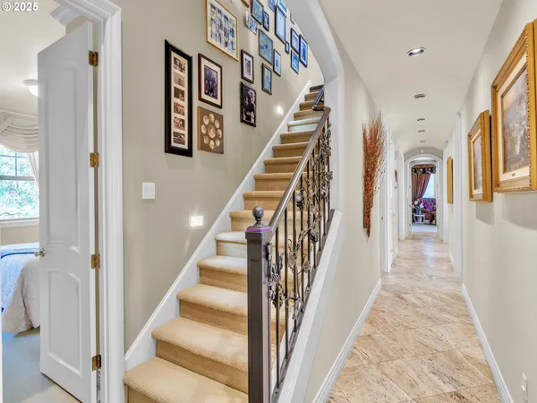 a view of staircase with lots of frames on wall and a table