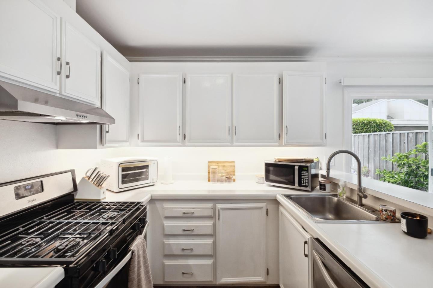 1287 Rosita Road Pacifica, CA 94044 - Photo 29 of 76 a kitchen with white cabinets a sink and appliances
