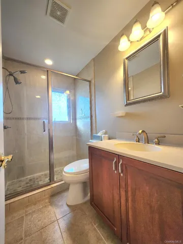 a bathroom with a granite countertop sink toilet and shower