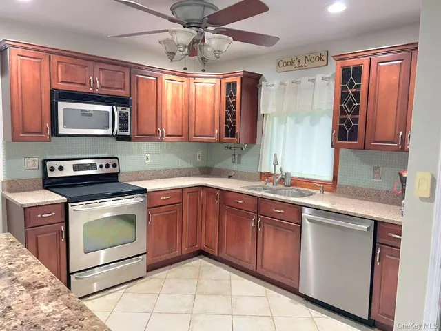 a kitchen with stainless steel appliances a stove sink and microwave