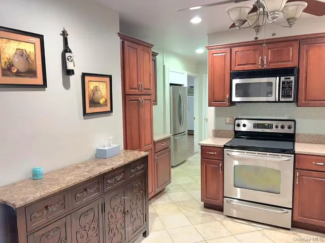 a kitchen with stainless steel appliances granite countertop a stove microwave and refrigerator