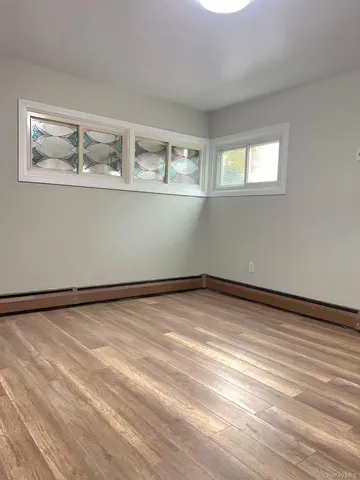 a view of a room with wooden floor and white walls