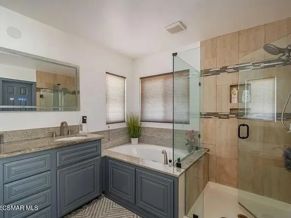 a bathroom with a granite countertop sink mirror bathtub and shower
