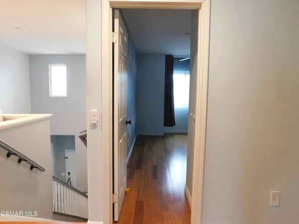 a view of a hallway with wooden floor and stairs