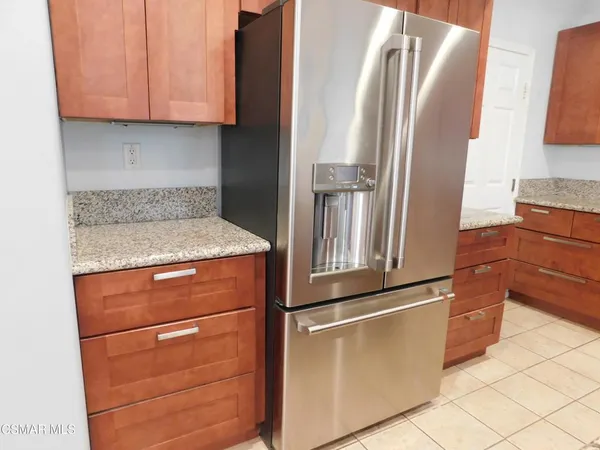 a kitchen with stainless steel appliances granite countertop a refrigerator and a stove