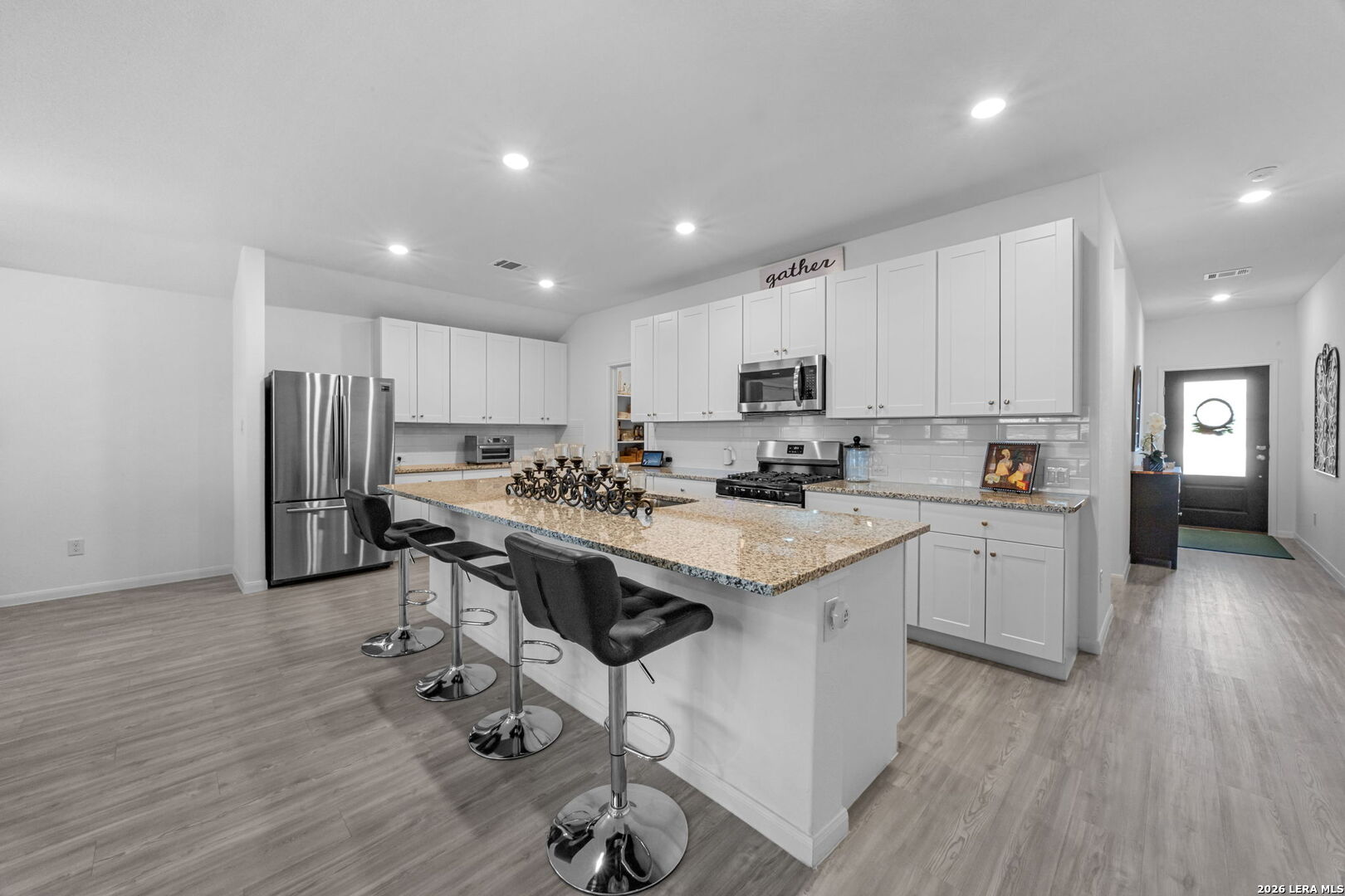 5781 Companion Loop Bulverde, TX 78163 - Photo 4 of 21 a kitchen with white cabinets and stainless steel appliances