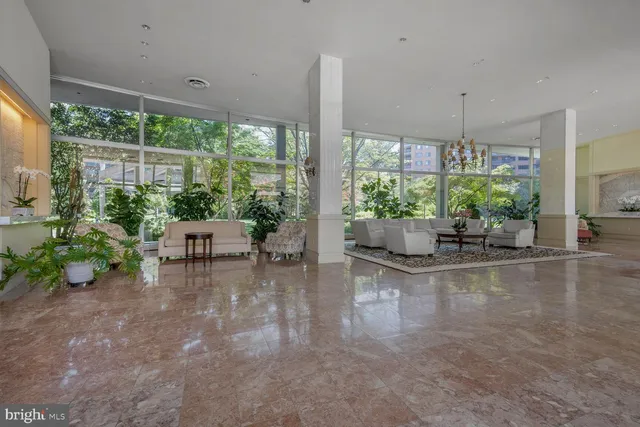 a living room with furniture and floor to ceiling windows