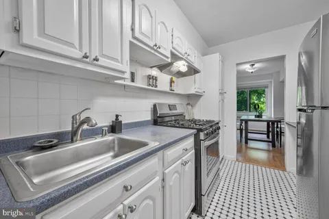 a kitchen with granite countertop a sink a stove and cabinets