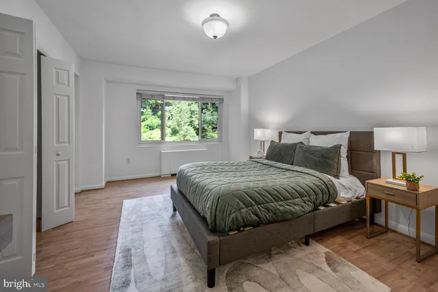 a spacious bedroom with a bed and a night stand