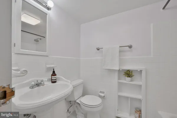 a bathroom with a toilet a sink and mirror