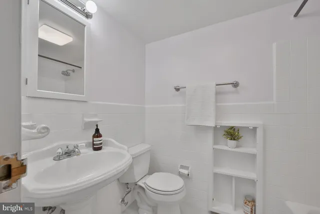 a bathroom with a toilet a sink and mirror