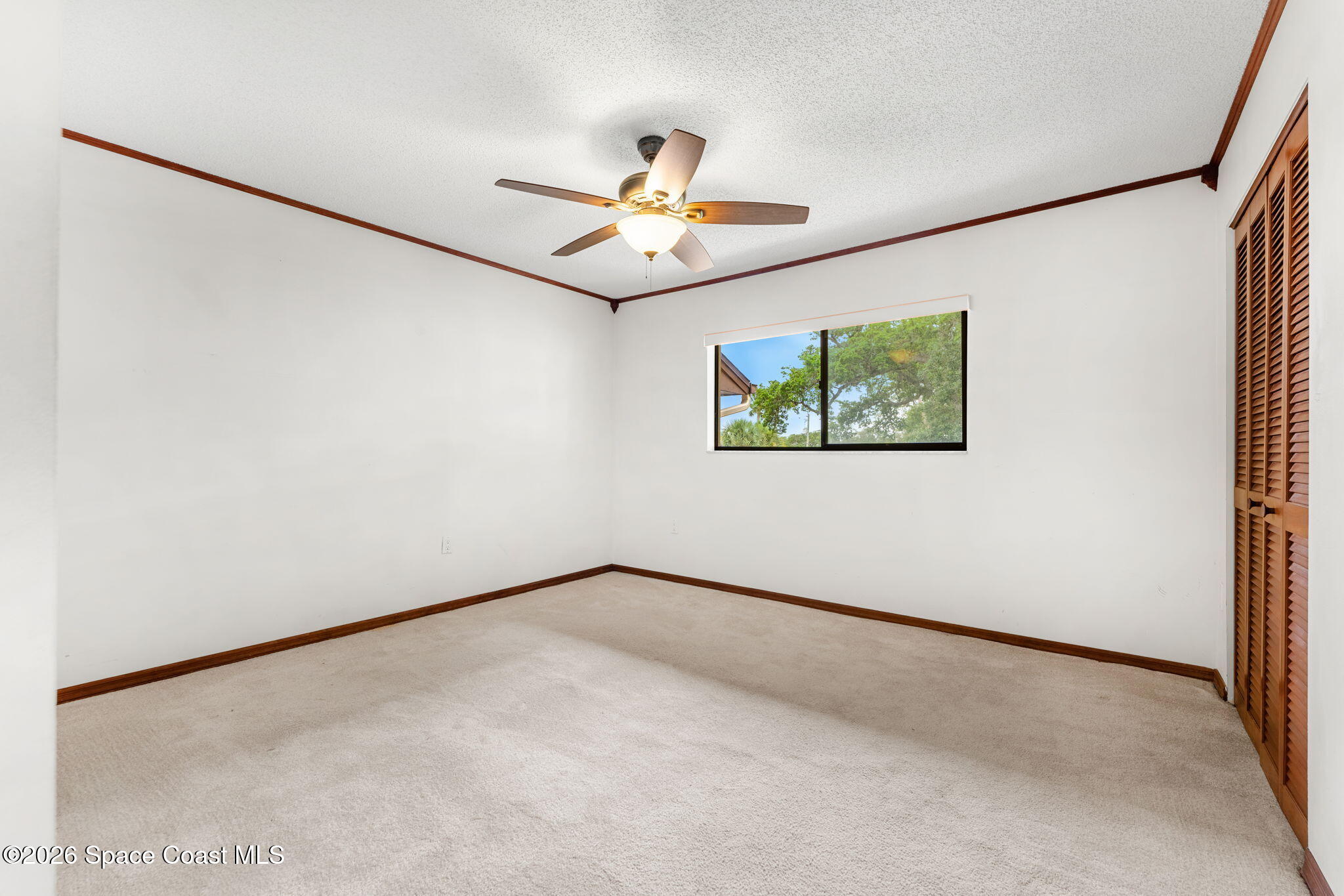 3121 Kirkland Road Northeast Palm Bay, FL 32905 - Photo 25 of 52 an empty room with windows and fan