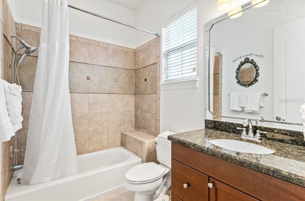 1227 Radiant Street Reunion, FL 34747 - Photo 40 of 70 a bathroom with a granite countertop sink toilet and shower