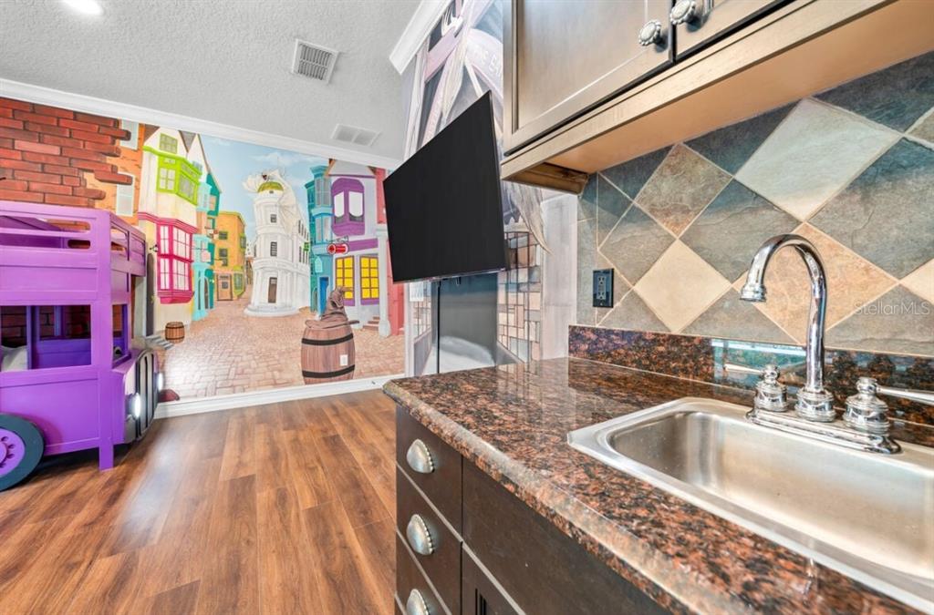 1227 Radiant Street Reunion, FL 34747 - Photo 44 of 70 a kitchen with stainless steel appliances granite countertop a sink a stove and a wooden floors