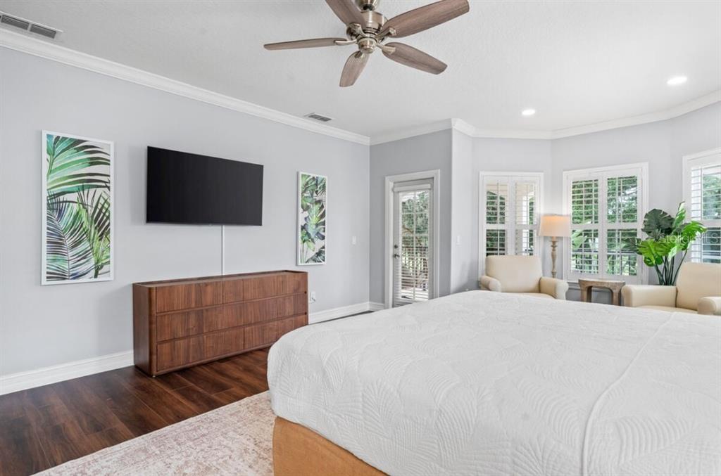 1227 Radiant Street Reunion, FL 34747 - Photo 52 of 70 a bedroom with a bed a couch and a flat screen tv