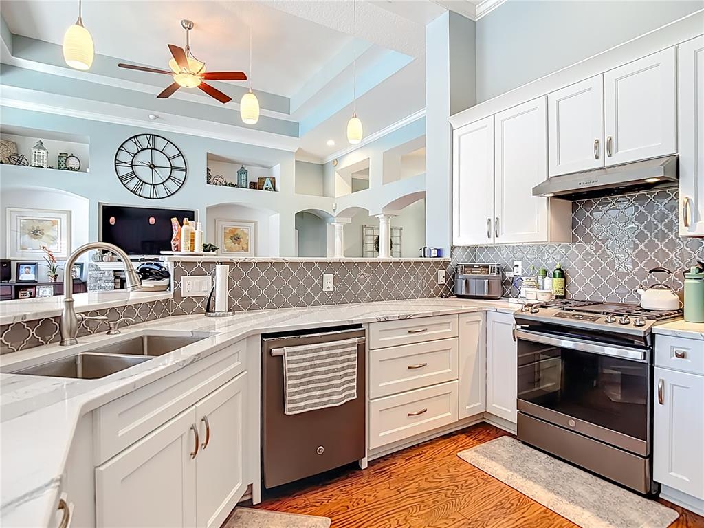 4805 Tea Rose Court Lutz, FL 33558 - Photo 20 of 59 a kitchen with stainless steel appliances granite countertop a stove and cabinets
