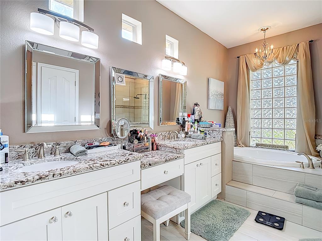 4805 Tea Rose Court Lutz, FL 33558 - Photo 33 of 59 a bathroom with a sink double vanity granite tub and a mirror
