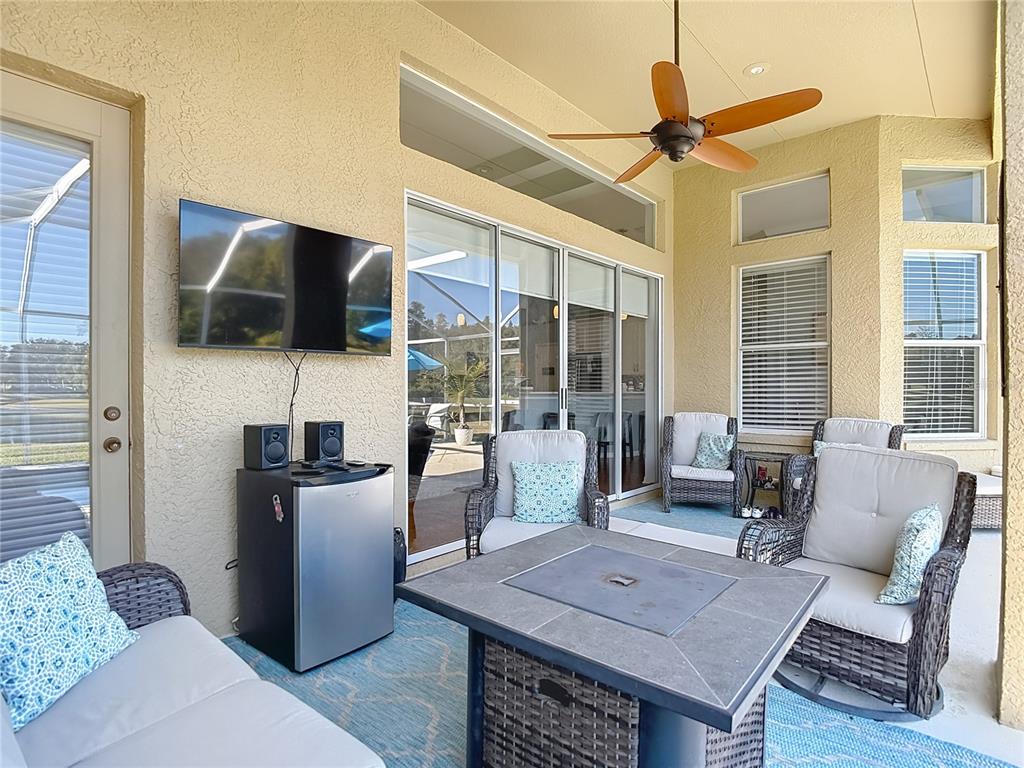 4805 Tea Rose Court Lutz, FL 33558 - Photo 44 of 59 a living room with furniture a flat screen tv and a large window