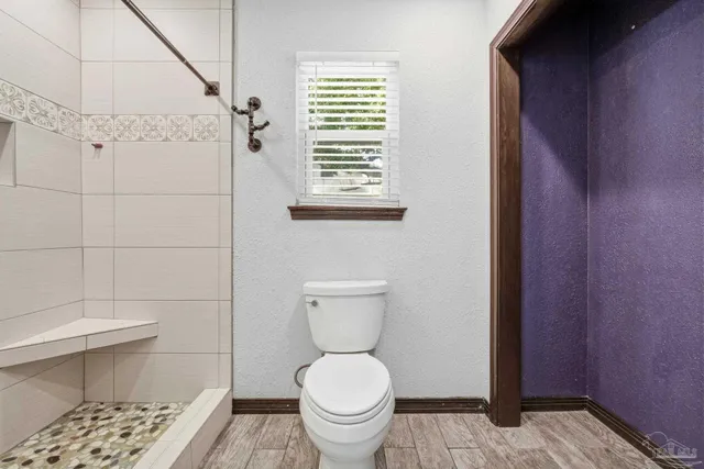 a bathroom with a toilet and a shower