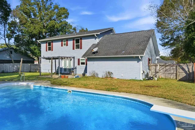 a view of a house with swimming pool and sitting area