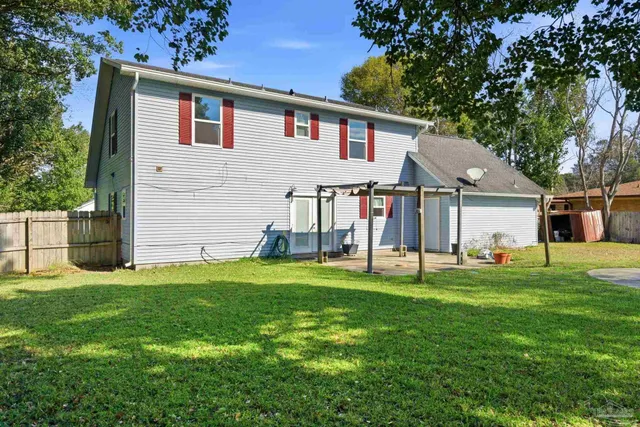a backyard of a house with table and chairs