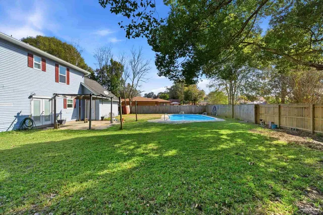 a view of a house with backyard and a tree