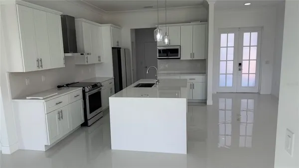 a kitchen with white cabinets and stainless steel appliances