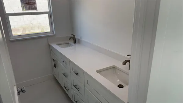 a bathroom with a sink a window and tub