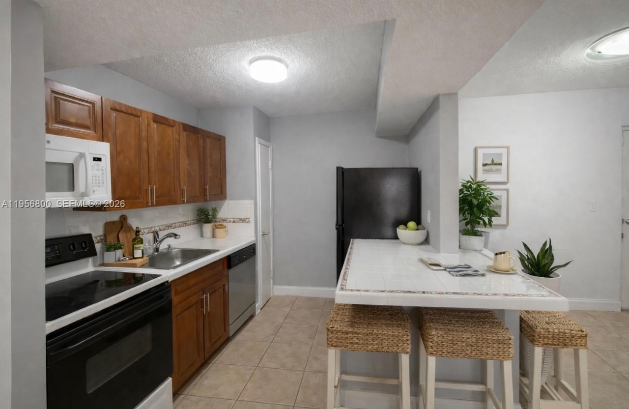 850 Southwest 129th Place, Unit 103 Miami, FL 33184 - Photo 1 of 8 a kitchen with a sink and cabinets
