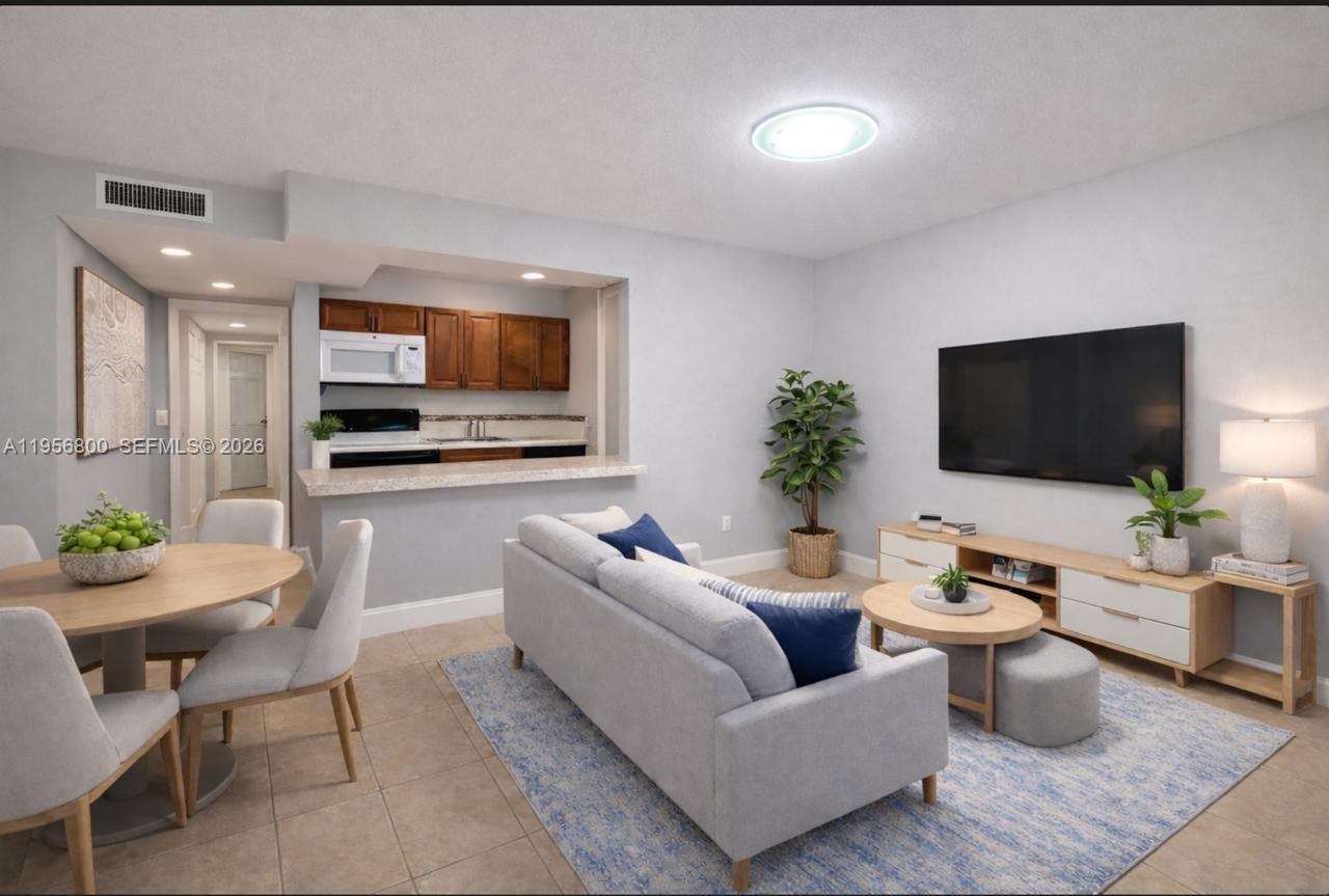 850 Southwest 129th Place, Unit 103 Miami, FL 33184 - Photo 2 of 8 a living room with furniture and a flat screen tv