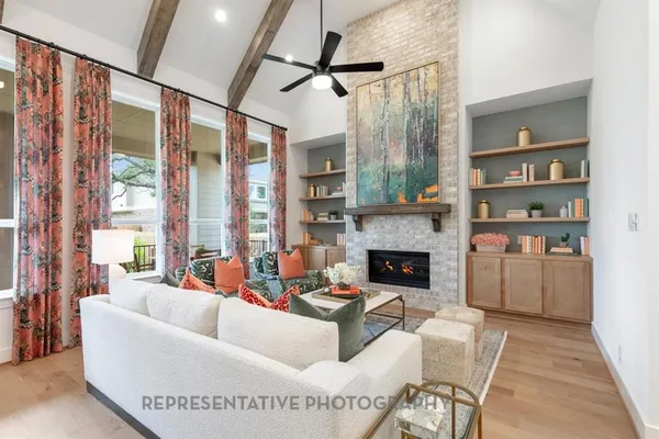 a living room with furniture a fireplace and a large window