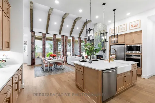 a kitchen with kitchen island a large island in the center windows a sink and a counter top space