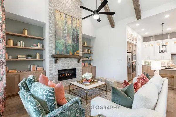 a living room with furniture fireplace and a large window