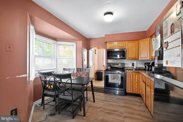 a kitchen with stainless steel appliances a refrigerator a stove a sink dishwasher with a dining table and chairs