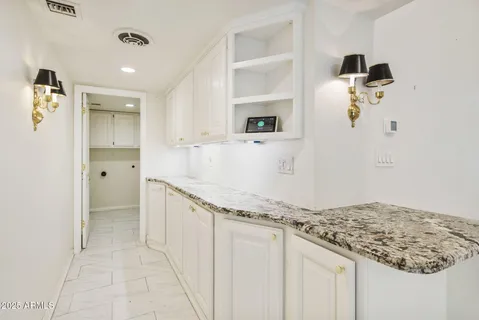 a kitchen with white cabinets and stainless steel appliances