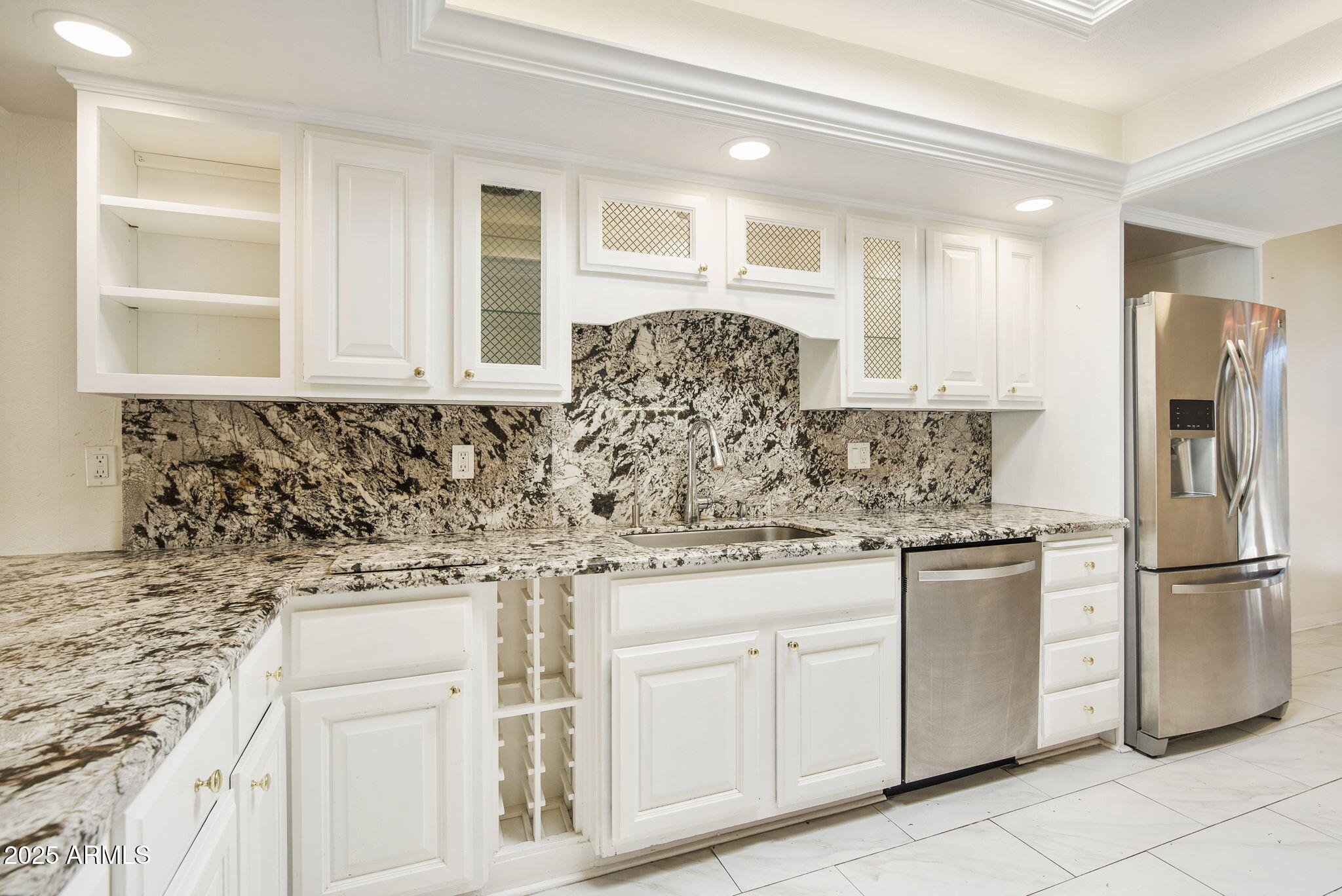 7365 East Valley View Road Scottsdale, AZ 85250 - Photo 9 of 45 a kitchen with white cabinets and stainless steel appliances
