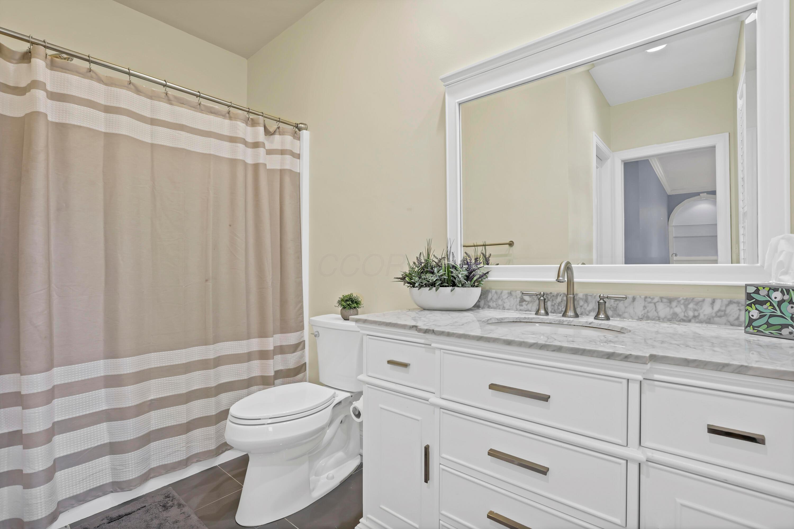 3575 State Rte 37 West Delaware, OH 43015 - Photo 84 of 106 Bathroom featuring a white vanity with a light-toned countertop, a large framed mirror, and a toilet